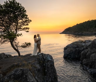 a bride and groom standing on a rock formation at creek point, British Columbia