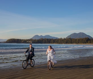 Tofino elopement photographer photographing the bride and groom on bikes