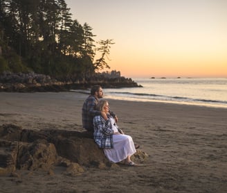 Couple watching the sunset at the beach in tofino during their elopement