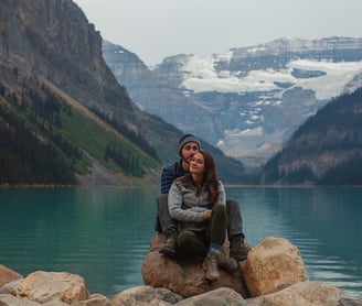 Couple sitting on a rock at Lake Louise during their photoshoot