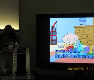 Girl sitting on a bed in the mirror watching cartoons