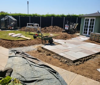 Sandstone paving being laid and flower beds being dug