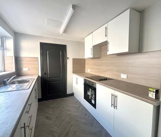 a kitchen with a stove top oven and a sink