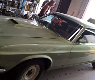 a man in a green shirt is standing next to a car