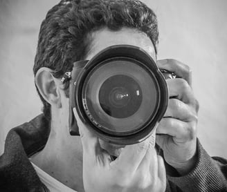 Artist Yous holding and pointing the dslr camera towards you