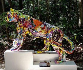 Uma escultura vibrante de onça-pintada com padrões coloridos, situada no Parque do Masp