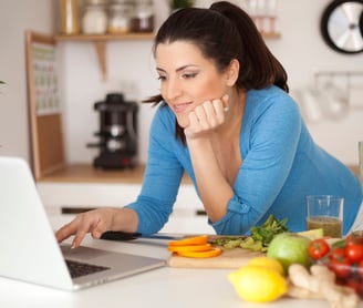 a woman is sitting at a table with a laptop