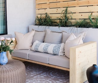 a couch with pillows and pillows on a patio