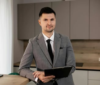 un hombre con traje y corbata de pie en una cocina