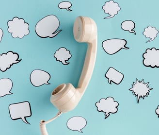 Combiné téléphonique sur fond bleu avec des bulles de dialogue illustrant la prise de contact