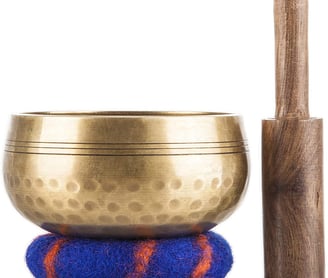a golden singing bowl with a wooden mallet and a wooden mallet