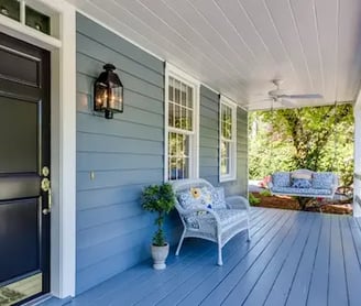 Blue house exterior with white trim and a cozy porch, showcasing Camas Painters, your trusted house painter.