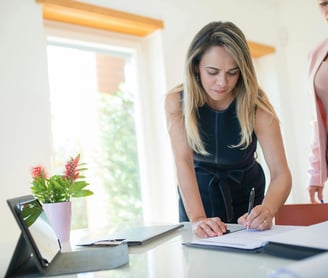 una mujer firmando un contrato
