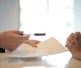 un hombre y una mujer sentados a una mesa con papeles