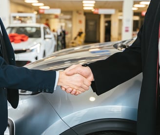 dos hombres se dan la mano en un concesionario de coches