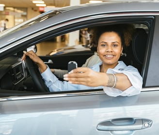 una mujer en un coche con un móvil en la mano