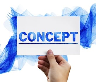 a person holding a piece of paper with the word concept
