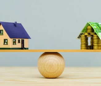 Uma casa e um monte de moeda, ambos em uma base que está centralizada sobre uma esfera.