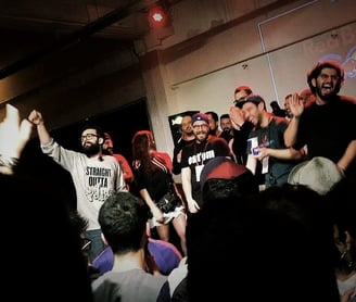 a man standing in front of a crowd of people in rap battle in the middle east