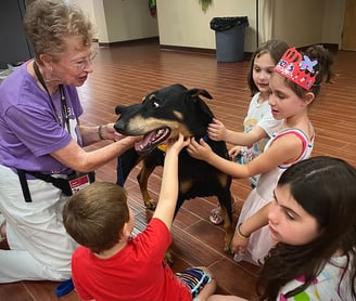 Tender Paws Therapy Animal Team Janet and Bentley interact with children.