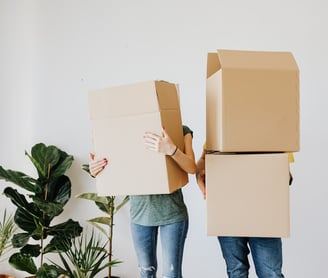Hombre y mujer sosteniendo cajas con cajas encima: Soluciones de Empaque | BeeTheBox.mx