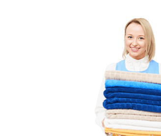 a woman holding a stack of towels and a stack of towels in commercial laundry