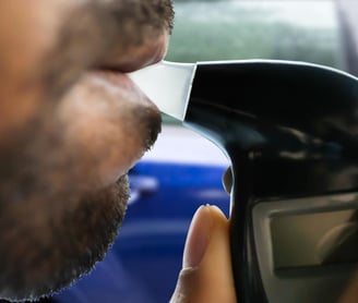 a man with a beard blowing into a breathalyzer