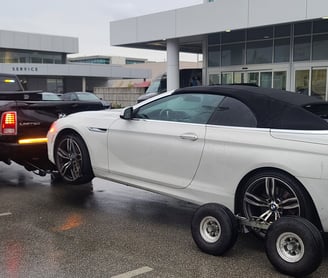 BMW 650i towed on wheel lift with collins dollys
