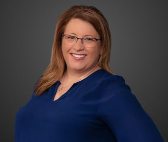 a woman in a blue shirt and glasses