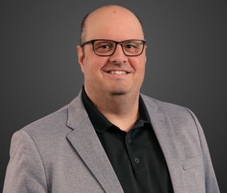 a man in a suit and glasses smiling