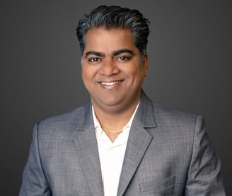 a man in a grey suit and white shirt