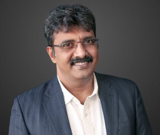 a man in a suit and glasses smiling