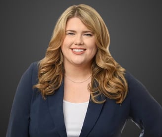 a blond woman in a blue jacket and white top