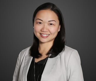 a woman in a gray jacket and black top