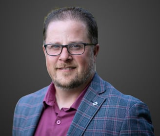 a man in a suit and glasses smiling