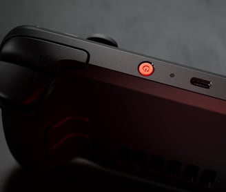 "Close-up of the Steam Deck OLED with a red power button, highlighting the sleek design and premium