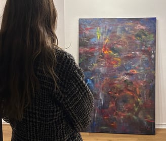 a woman standing in front of a painting