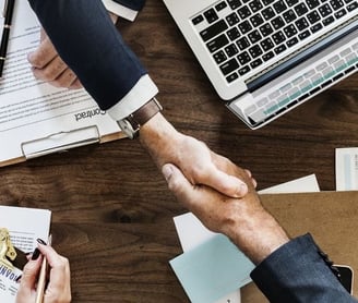 a group of people shaking hands over a desk