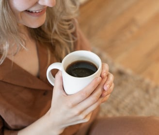 A woman enjoying a cup of black coffee