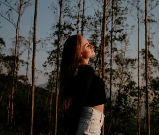A woman spending some time amongst the trees in the forest