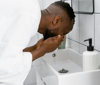 A man cleansing his face as part of his skincare routine