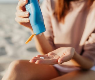 Woman on the beach applying sunscreen/sunblock