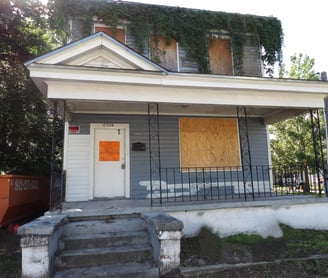a house with boarded windows and boarded windows