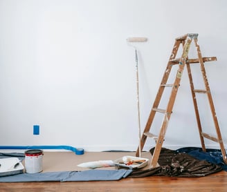 una escalera con pintura y un rodillo de pintura