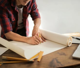 un hombre sostiene un rollo de papel y un lápiz