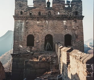 Great Wall Watchtower, 1970 – Mid-range shot of a Chinese guard standing atop a restored watchtower
