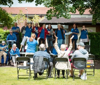 Choir singing on stage in park