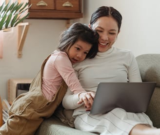 a woman and her daughter sitting on a couch