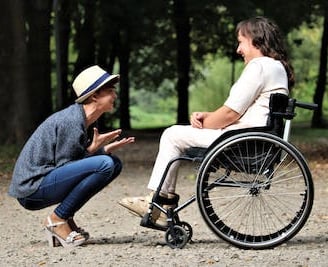 a woman in a wheelchair is talking to a man in a wheelchair