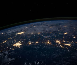 A stunning view of Earth from space, showcasing glowing city lights connected across the planet's su